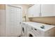 Laundry room with modern appliances, ample storage and a white door at 14096 Pullman Dr, Spring Hill, FL 34609