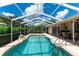 Inviting screened-in pool with a rock waterfall feature, providing a relaxing backyard oasis at 14096 Pullman Dr, Spring Hill, FL 34609