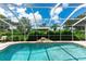 Beautiful screened-in pool with a charming waterfall feature surrounded by well-maintained landscaping at 14096 Pullman Dr, Spring Hill, FL 34609