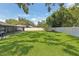 Large backyard featuring healthy, green grass, a white fence, and a patio at 1513 Loretta Ct, Brandon, FL 33511