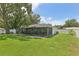 Spacious backyard with lush green grass, patio, and screened in porch offer outdoor enjoyment at 1513 Loretta Ct, Brandon, FL 33511