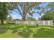 Large backyard with lush green grass, mature trees, and privacy fence offers a serene outdoor space at 1513 Loretta Ct, Brandon, FL 33511