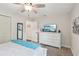 Bedroom showcasing a white dresser, ceiling fan, large window, and doorway at 1513 Loretta Ct, Brandon, FL 33511