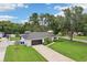Well-maintained front yard with lush landscaping, mature trees, and a long driveway leading to the garage at 1513 Loretta Ct, Brandon, FL 33511