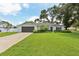 Beautiful home with a lush green lawn, mature trees, and attached garage at 1513 Loretta Ct, Brandon, FL 33511