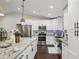 Bright kitchen with white cabinets, stainless appliances, granite counters, and a stylish tile backsplash at 1513 Loretta Ct, Brandon, FL 33511
