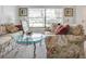 Comfortable living room featuring floral sofas and a glass table by a bright window at 1610 Sanderling Ct, Brandon, FL 33511