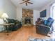 Inviting living room with a stone fireplace, dark leather seating, and wood flooring at 1610 Sanderling Ct, Brandon, FL 33511