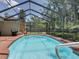 Sparkling screened-in pool surrounded by a spacious deck and lush landscaping at 1610 Sanderling Ct, Brandon, FL 33511