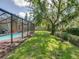Sparkling screened-in pool with spacious backyard and lush landscaping at 1610 Sanderling Ct, Brandon, FL 33511