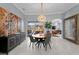 Elegant dining area with artwork, modern light fixture, and view of the outdoor living space and kitchen at 17807 Arbor Greene Dr, Tampa, FL 33647