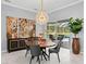 Bright dining room featuring a round table, statement light fixture, and view of the outdoor pool area at 17807 Arbor Greene Dr, Tampa, FL 33647