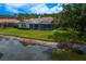 Exterior of the home showing a screened pool, lush lawn, and waterfront view at 17807 Arbor Greene Dr, Tampa, FL 33647