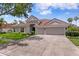 Charming single-story home with tile roof, well-manicured lawn and a three-car garage at 17807 Arbor Greene Dr, Tampa, FL 33647