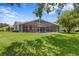 Home's screened-in pool and outdoor living space are surrounded by a well-maintained lawn at 17807 Arbor Greene Dr, Tampa, FL 33647