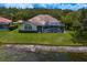 Exterior view of a home highlighting a screened pool area, lush lawn, and waterfront setting at 17807 Arbor Greene Dr, Tampa, FL 33647
