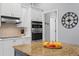 Close-up of the kitchen island, white cabinets, stainless appliances, and breakfast bar at 17807 Arbor Greene Dr, Tampa, FL 33647