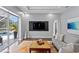 Open-concept living room with a large TV, modern decor, and sliding doors to the outdoor pool at 17807 Arbor Greene Dr, Tampa, FL 33647