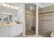 Updated main bathroom featuring a glass enclosed shower with a seat and a double sink vanity at 17807 Arbor Greene Dr, Tampa, FL 33647
