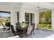Covered patio area with comfortable seating and a view of the lush backyard and pool at 17807 Arbor Greene Dr, Tampa, FL 33647