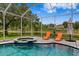 Inviting screened-in pool with a spa and lounge chairs offers a relaxing outdoor space at 17807 Arbor Greene Dr, Tampa, FL 33647
