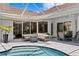 Inviting pool area with a covered patio, featuring a fire pit and comfortable lounge seating at 17807 Arbor Greene Dr, Tampa, FL 33647