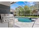 Outdoor kitchen view of the screened-in pool and spa area at 17807 Arbor Greene Dr, Tampa, FL 33647