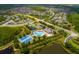 Expansive aerial view of a community featuring a pool, clubhouse, tennis courts and verdant landscaping at 18508 Merseyside Loop, Land O Lakes, FL 34638