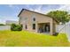 Expansive backyard featuring a covered patio area, lush green lawn, and secure privacy fence at 18508 Merseyside Loop, Land O Lakes, FL 34638