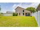 Spacious backyard with lush green grass, a white picket fence, and plenty of room to enjoy at 18508 Merseyside Loop, Land O Lakes, FL 34638