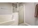 Well-lit bathroom featuring a tiled bathtub with glass shower doors, and a decorative towel rack at 18508 Merseyside Loop, Land O Lakes, FL 34638