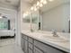Bathroom featuring double sinks, modern fixtures, and a view into the bedroom at 18508 Merseyside Loop, Land O Lakes, FL 34638