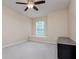 Neutral bedroom features natural light from the window and a fan with lights above at 18508 Merseyside Loop, Land O Lakes, FL 34638