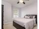 Bright bedroom features a comfortable bed, a window seat, and a ceiling fan for added comfort at 18508 Merseyside Loop, Land O Lakes, FL 34638