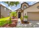 Charming home with a well-manicured lawn, mature landscaping, and a covered front entry at 18508 Merseyside Loop, Land O Lakes, FL 34638
