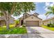 Inviting two-story home with a two-car garage, mature trees, and well-maintained lawn at 18508 Merseyside Loop, Land O Lakes, FL 34638