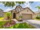 Beautifully landscaped home featuring a two-car garage, a covered front entry, and a manicured lawn at 18508 Merseyside Loop, Land O Lakes, FL 34638