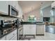 Bright kitchen features stainless steel appliances, granite countertops, and white cabinets at 18508 Merseyside Loop, Land O Lakes, FL 34638
