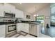 Well-appointed kitchen with stainless steel appliances, white cabinets, and a view into the dining area at 18508 Merseyside Loop, Land O Lakes, FL 34638