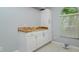 Charming dry bar with custom countertop, white cabinets, and a window at 18508 Merseyside Loop, Land O Lakes, FL 34638