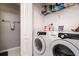 Laundry room featuring modern washer and dryer, storage shelves, and access to additional space at 18508 Merseyside Loop, Land O Lakes, FL 34638