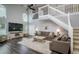 Spacious living room with dark wood floors, tall ceilings, comfortable couches, and a staircase at 18508 Merseyside Loop, Land O Lakes, FL 34638
