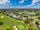 Golf course community aerial shot of a neighborhood with single Gathering homes and lake views at 18549 Grand Club Dr, Hudson, FL 34667