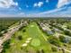 Aerial view of a golf course community with single Gathering homes surrounded by lush landscaping at 18549 Grand Club Dr, Hudson, FL 34667