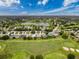 Wide aerial shot of a golf course community with single Gathering homes and lake in the background at 18549 Grand Club Dr, Hudson, FL 34667