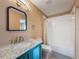 Bathroom with blue vanity, marble countertop, framed mirror, updated fixtures, and a shower with curtain at 18549 Grand Club Dr, Hudson, FL 34667