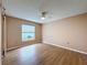 Bedroom featuring hardwood floors, a ceiling fan, and a large window at 18549 Grand Club Dr, Hudson, FL 34667