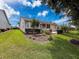 Exterior view of the home with meticulous landscaping, lawn, and patio area at 18549 Grand Club Dr, Hudson, FL 34667