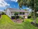 Rear exterior showing manicured landscaping, a covered patio, and a well-maintained lawn at 18549 Grand Club Dr, Hudson, FL 34667