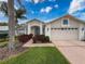 Beautiful house with a two-car garage, arched entryway, and landscaped front yard at 18549 Grand Club Dr, Hudson, FL 34667